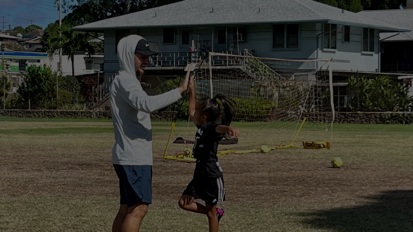 A young soccer player high fiving coach Micah