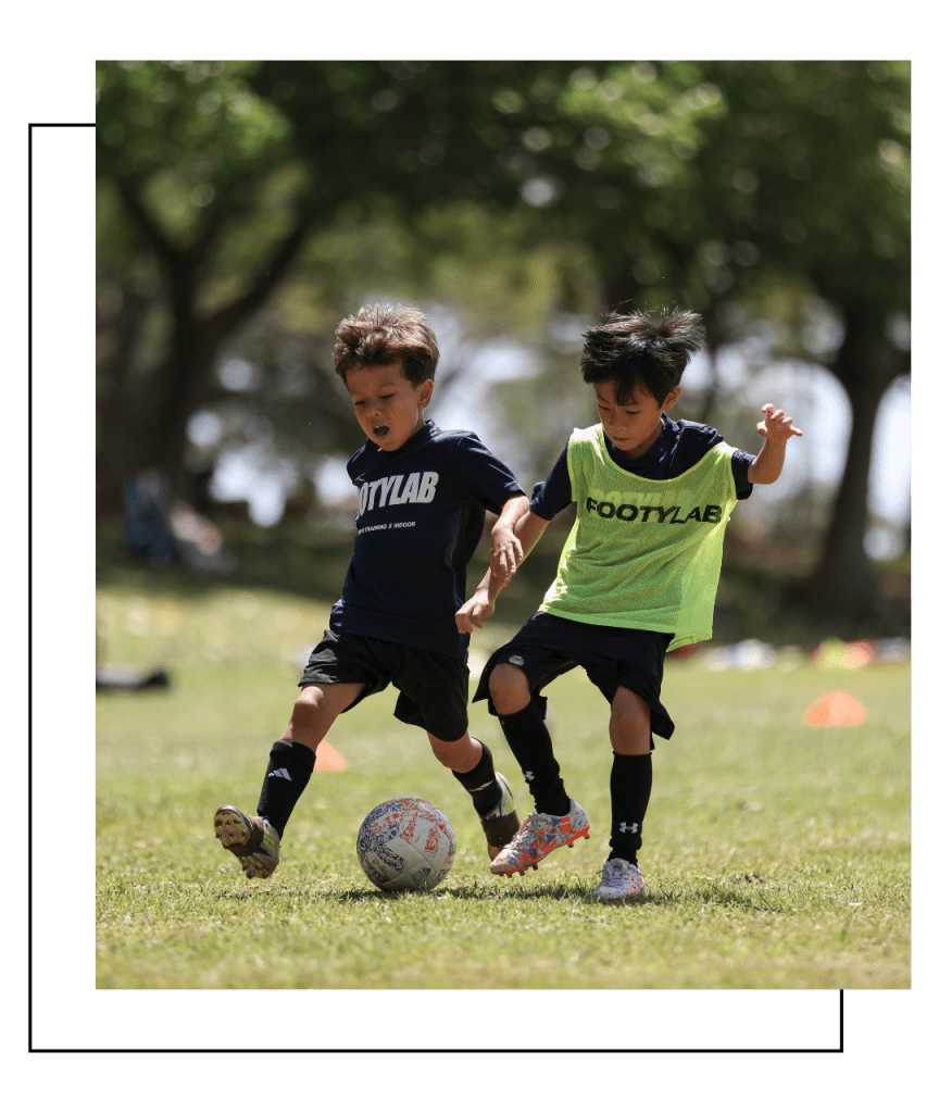 two young Keiki soccer players compete for a ball